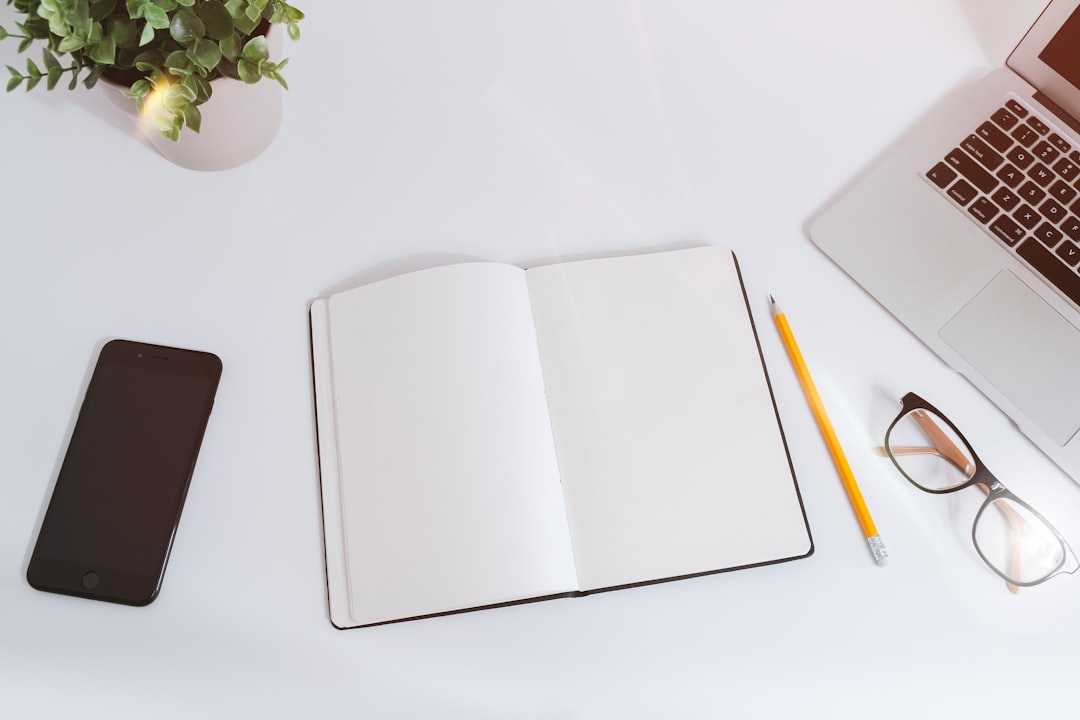 An open book lying flat beside a cup of coffee and a pair of glasses